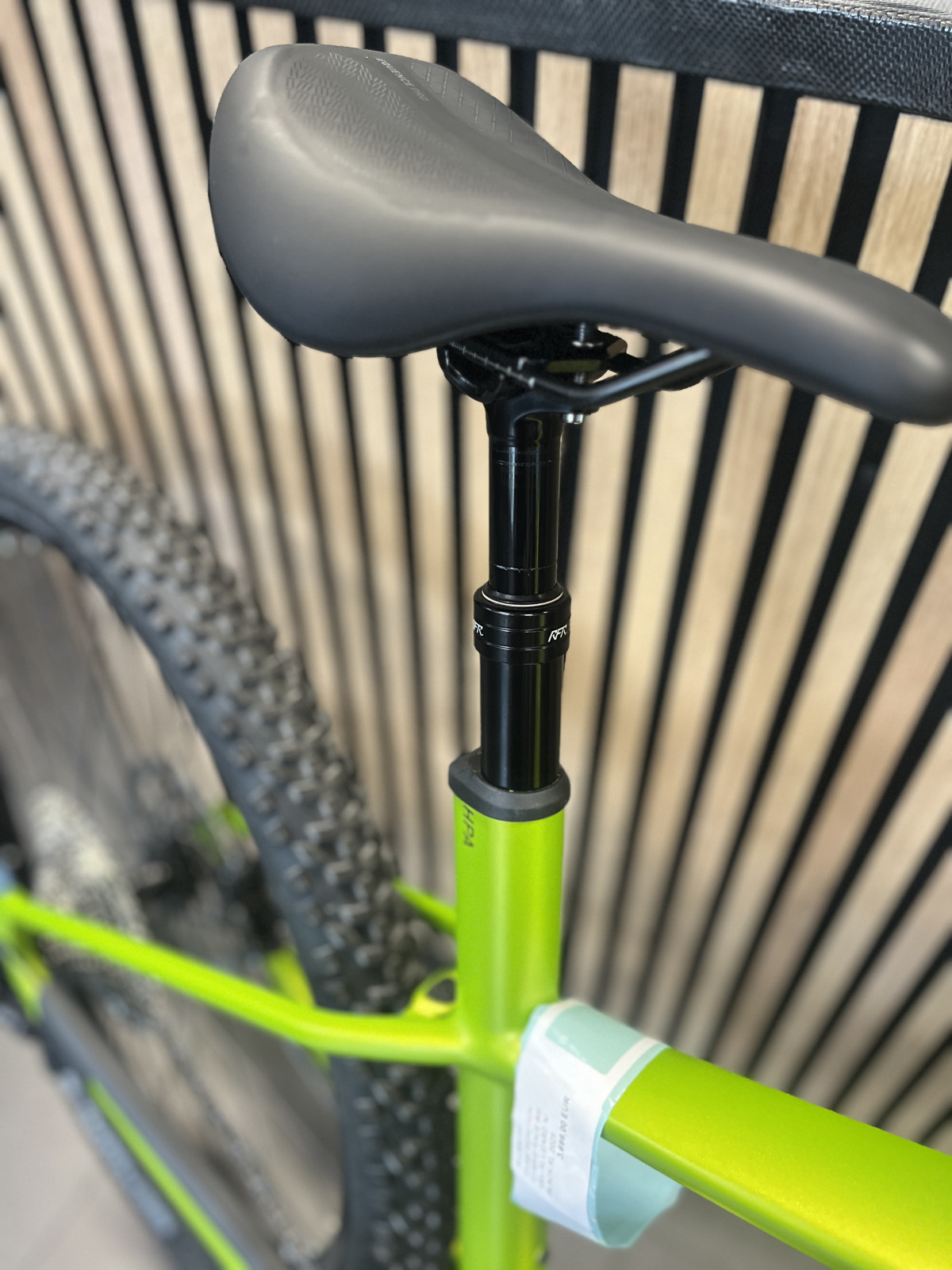 Spuščena potopna sedežna opora na zelenem gorskem kolesu za varen spust.